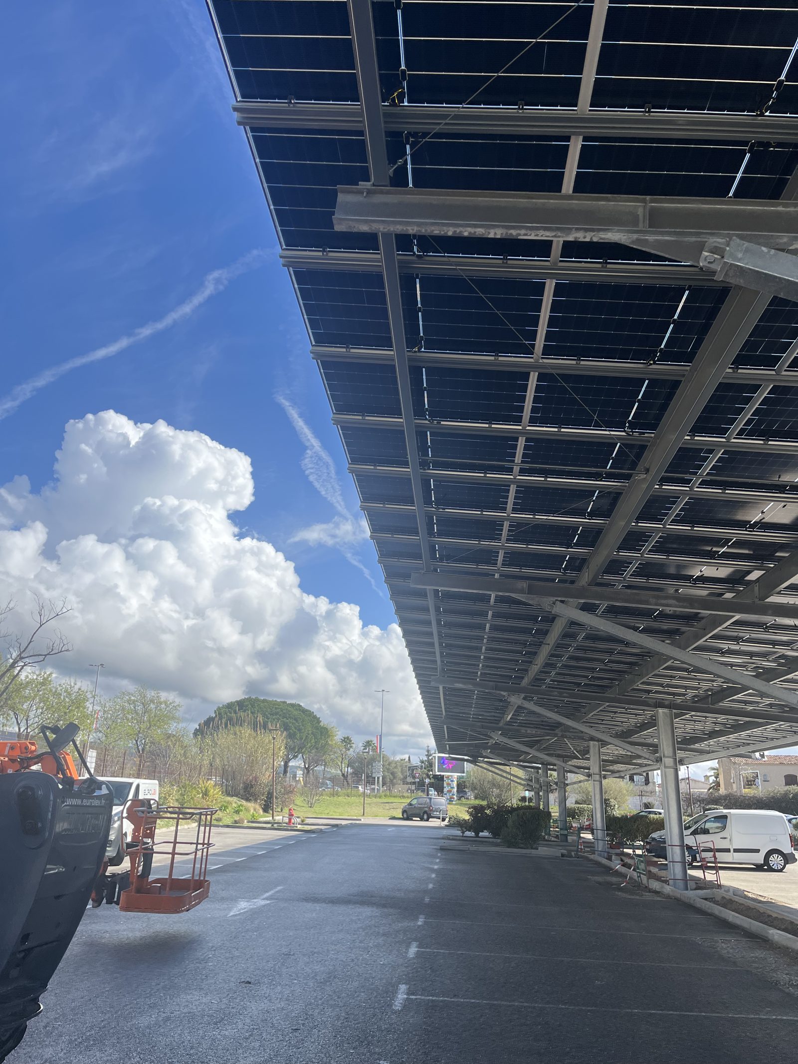 Ombrière de parking photovoltaïque vue depuis dessous montrant la structure acier